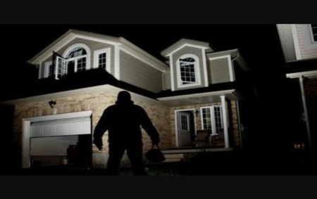 Robber backlit infront of house